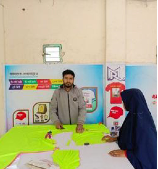 Robiul cutting fabric on large work table with assistant